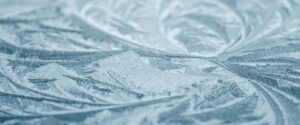 Nahaufnahme von komplexen, hellblauen Eisblumen-Mustern auf einer Oberfläche, mit scharfen Details und weicher Unschärfe im Hintergrund | C-Rope Kamerazubehör